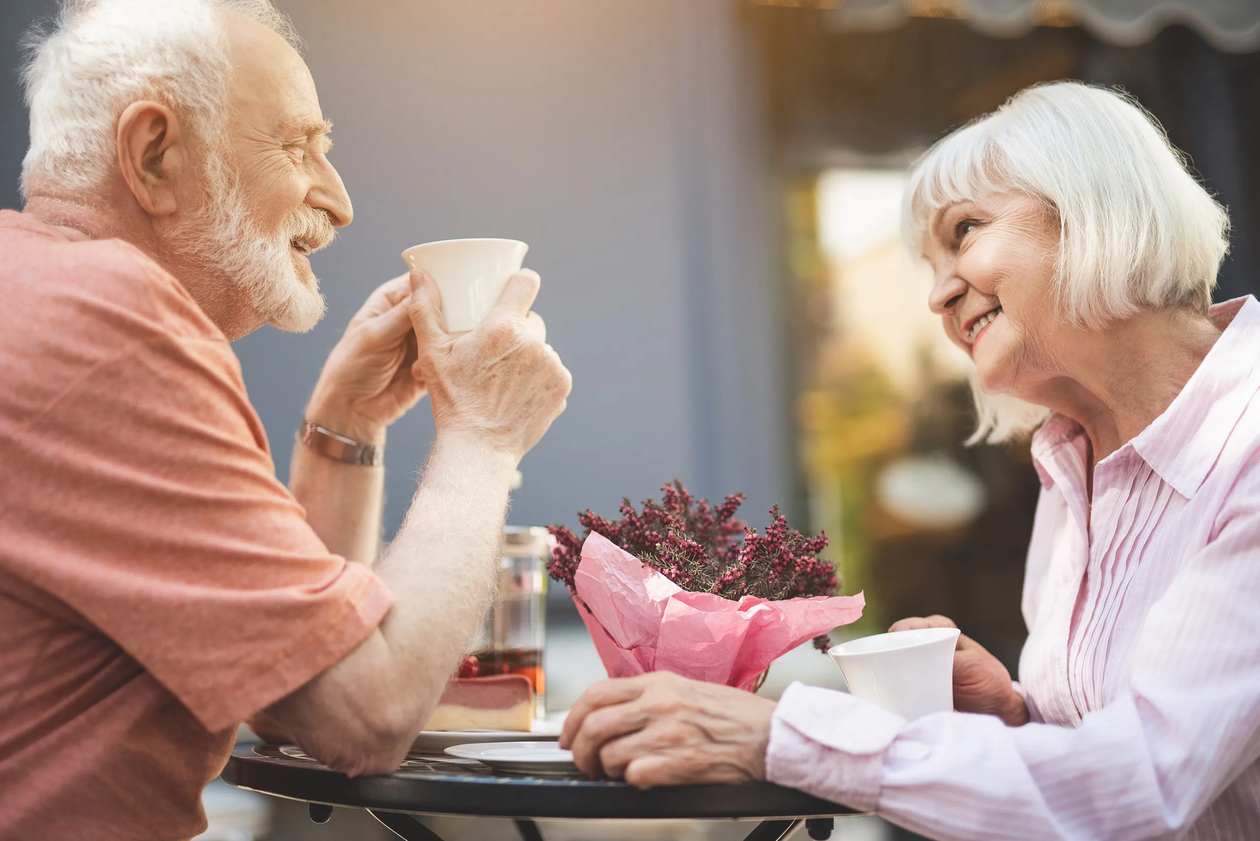Side view profile of happy senior couple drinking tea in cafe outdoors Side view profile of happy senior couple drinking tea in cafe outdoors